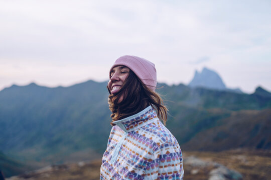 Smiling woman wearing knit hat standing on mountain around Ibones of Anayet