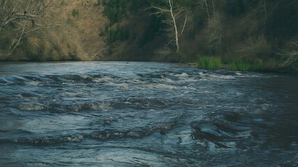 Dark Blue River Water with Gentle Waves and Forested Shoreline