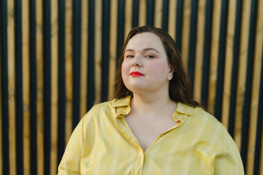 Plus size woman in front of wall
