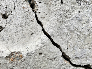 Concrete Wall With Deep Crack. Damaged concrete surface with long dramatic black crack.