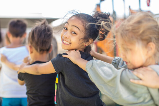 Happy children making a conga line in kindergarten