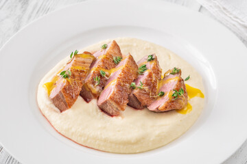 Sliced Duck Breast with Sauce and Thyme on Mashed Potato Bed