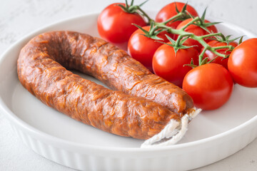 Curved Chorizo and Cherry Tomatoes Arranged Neatly on Minimal White Ceramic Plate