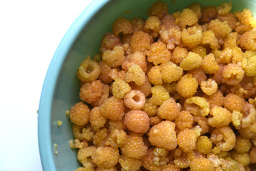 Yellow raspberries in a bowl. Juicy sweet yellow berries.