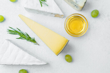 Cheese platter with assorted varieties, grapes, and honey for tasting