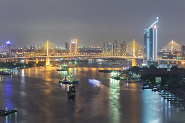 Naklejka premium Aerial view of Bangkok city night light at Chao Phaya riverfront and bridge across the river with central business district.