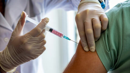 A close-up medical photograph of a vaccination injection being administered.