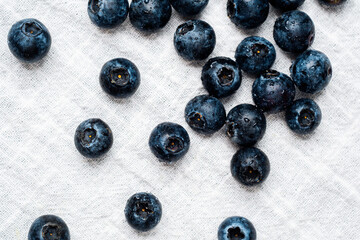 Fresh blueberries scattered on a linen cloth create a vibrant natural display