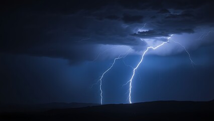 Dramatic lightning strike over a dark stormy landscape with electric blue flashes illuminating clouds.
