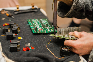 An electrician soldering a circuit board at home