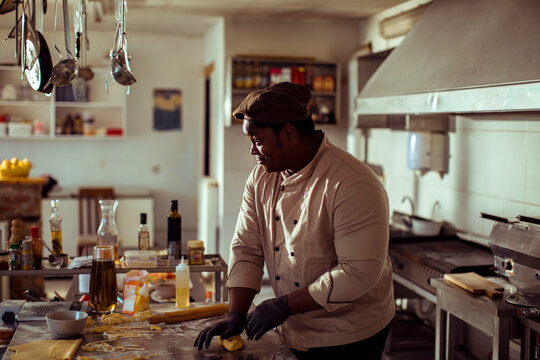 Black chef making fresh pasta in professional kitchen - Powered by Adobe