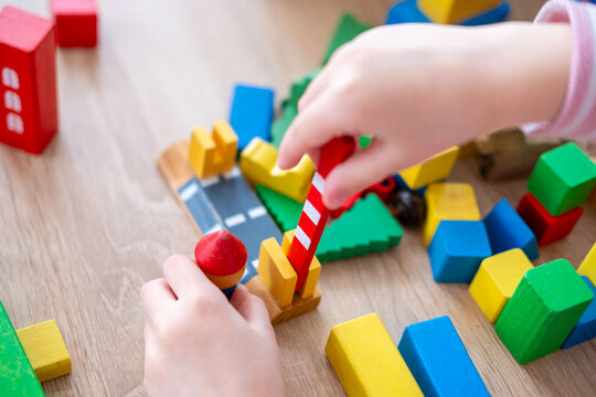 Child fun playing with wooden toys, play time, Colorful blocks and figures on table. Early education, fine motor skills concept