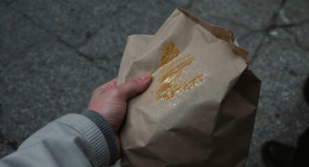 Hand Holding Brown Paper Bag with Gold Stamp