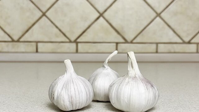 Close-up of woman's hand moving garlic cloves on kitchen countertop after inspection, preparing for cooking, fresh seasoning, home kitchen scene, natural light, healthy food concept