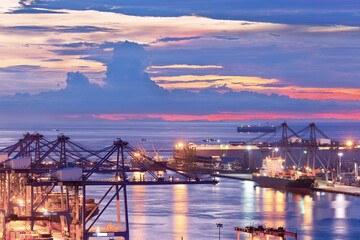 Obraz premium Background for cranes and industrial cargo ships in port at twilight.