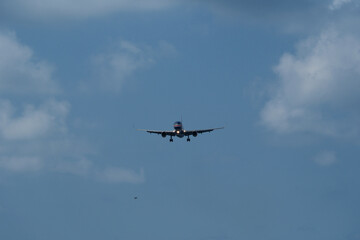 The airplane approaches the airport against a backdrop of clouds. The airplane is ready to land. Airplane in the cloudy sky.