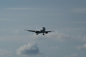 The airplane approaches the airport against a backdrop of clouds. The airplane is ready to land. Airplane in the cloudy sky.