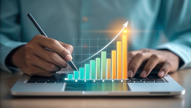 Analyzing a growing financial performance chart with a stylus on a laptop keyboard