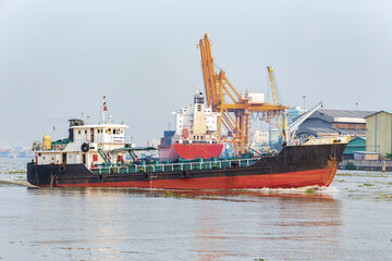 Fototapeta premium Container Cargo freight ship beside working crane bridge in the