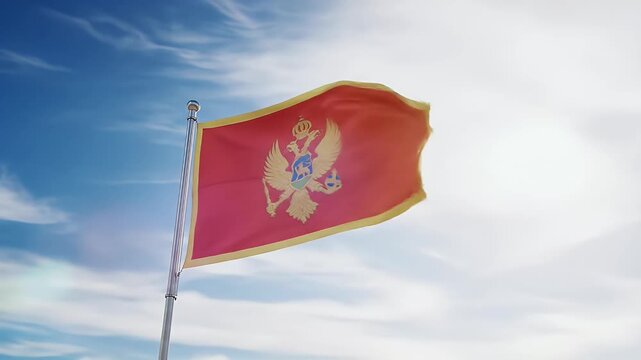 Montenegro's national flag billows proudly in a bright, sunny sky.
