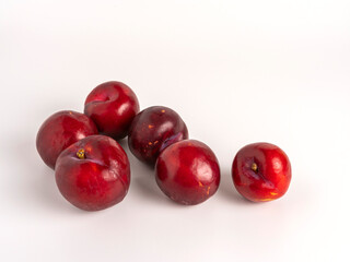 Ripe red plums isolated on white background, fresh, juicy, healthy, and organic.

