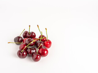 Juicy ripe cherries in a pile, vibrant and natural on white backdrop.
