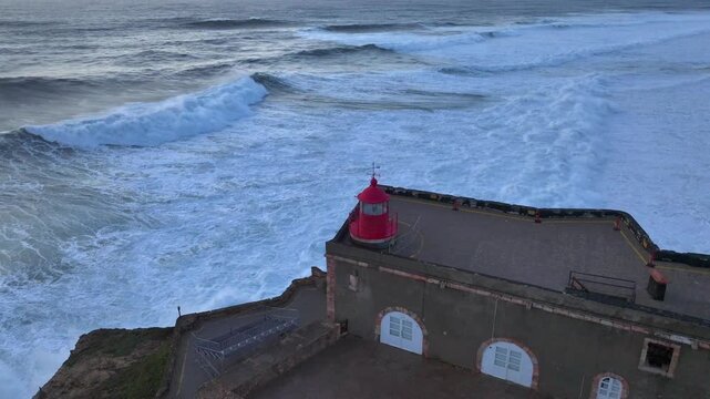 Lighthouse of Nazare, Farol da Nazare. The world's biggest waves in Portugal, Aerial Drone Shot During Sunset Time.