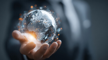 A hand holding a digital globe with glowing connections in a dark business setting close up view