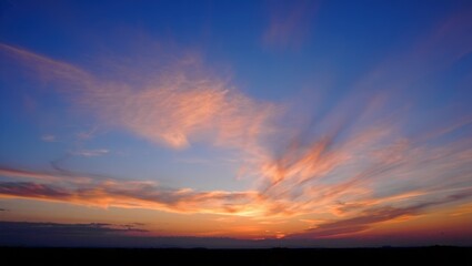 Obraz premium Dramatic sunset sky with fiery clouds and deep blue hues