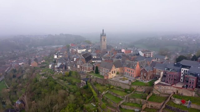 Aerial view of the ancient Thuin cityscape, where a prominent tower rises amidst a cluster of buildings and terraced landscapes, Thuin, Wallonia, Belgium.