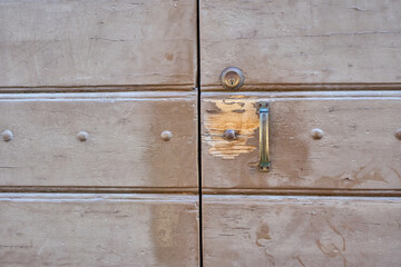Weathered Wooden Door Shows Signs of Age and Wear in a Rustic Location Under Natural Light