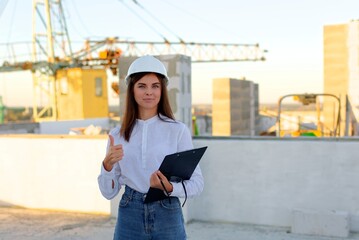 Female engineer showing a document to a construction worker on a rooftop