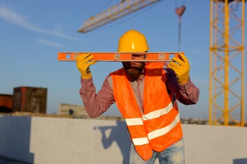 Construction manager and engineer discussing building project on site with crane in background