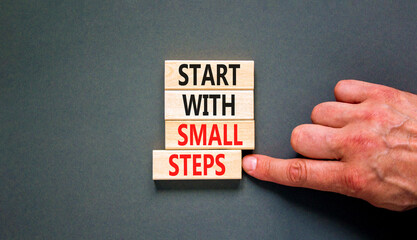 Start with small steps symbol. Concept words phrase Start with small steps on beautiful wooden blocks. Beautiful grey background. Businessman hand. Business Start with small steps concept. Copy space.