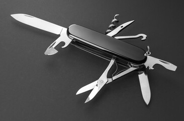 Multifunction army pocket folding knife isolated on black background