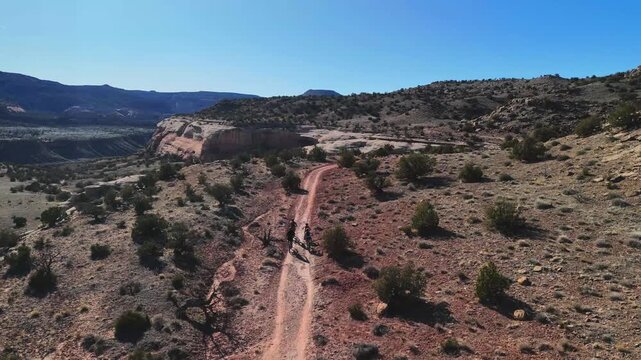 Aerial view of a rugged trail winding through the arid landscape, the red earth contrasting with the sparse green vegetation, Fruita, Colorado, United States.