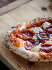 Savory Pepperoni Pizza on Wooden Table – Crispy Crust, Melted Cheese, and Spicy Sausage Toppings