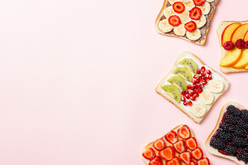 Assorted fruit toasts on pink background. Healthy breakfast concept with copy space. Top view, flat lay.