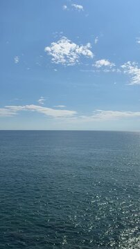 Blue sparkling ocean and sky, vertical video.