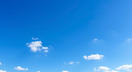 Clear blue sky with scattered clouds