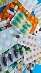 Various colorful medication capsules and tablets spread over a blue surface at a pharmacy
