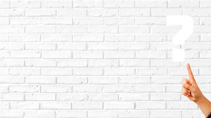 Hand pointing at empty space on a white brick wall, creating a visual opportunity for text or design elements, ideal for advertising or promotional content with copy space