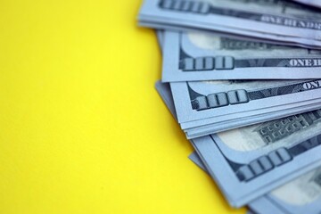 Big amount of United States hundred dollar bills on yellow background