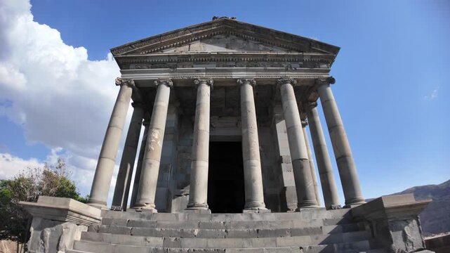 Garni Temple, a first-century hellenistic ionic temple near Garni, Armenia, stands majestically against a vibrant blue sky, showcasing its well-preserved columns and intricate stonework