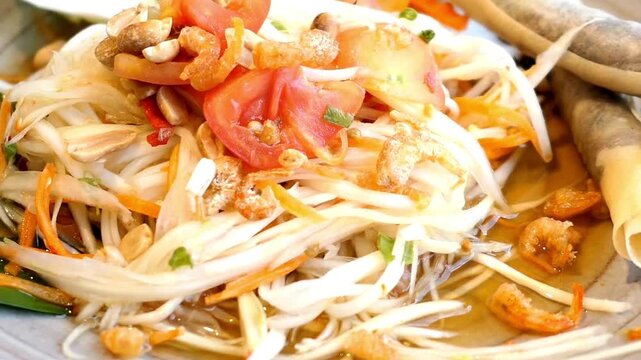 Close up of thai papaya salad or som tum with tomatoes