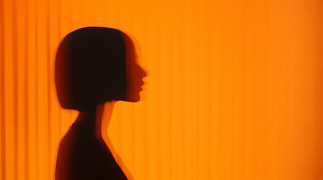 Silhouette of a person with a short haircut against an orange background. - Powered by Adobe
