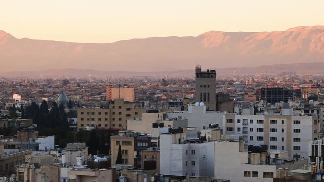 Panoramic view of the roofs of Shiraz, sunrise over the city, against the backdrop of mountains. a city in southern Iran, a center of nuclear research. Shiraz is a city of poetry, wine and roses.