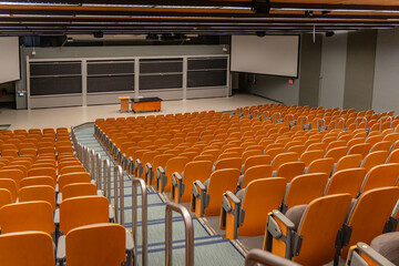 Naklejka premium Empty university lecture hall with seen from the rear with empty seats and professor's desk.