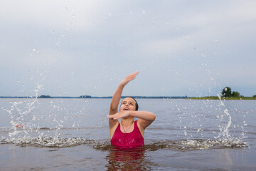 girl in a red swimsuit swimming in the lake
