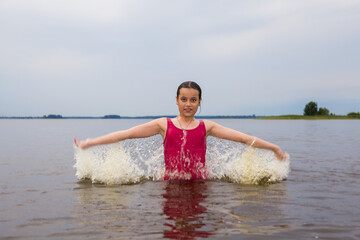 girl in a red swimsuit swimming in the lake